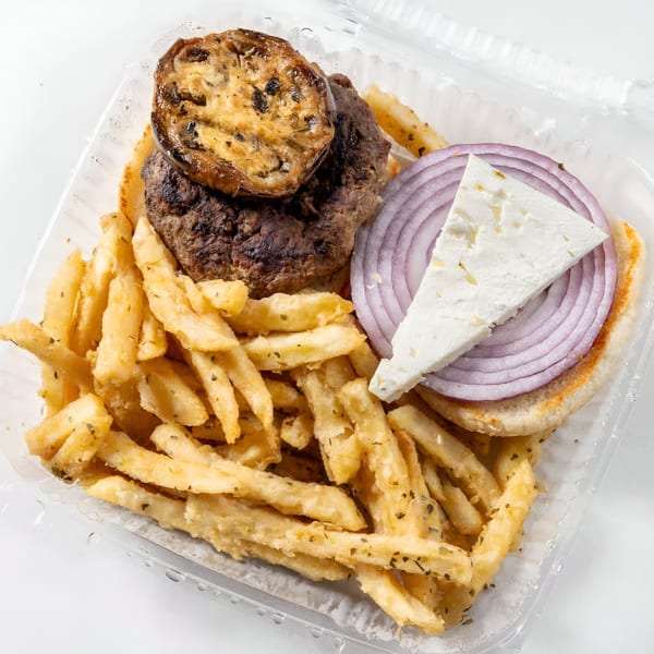 Greek Town's burger with grilled eggplant, red onion, feta, and seasoned fries in a takeout container.